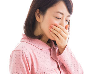 つわりで口を手で押さえる妊婦