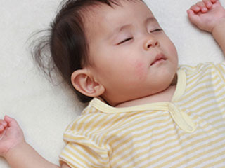 バンザイポーズで眠る赤ちゃん