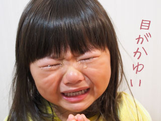目を閉じて涙をこぼす子供