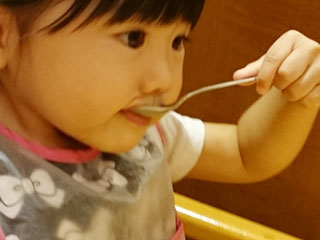 スプーンで食事する子供