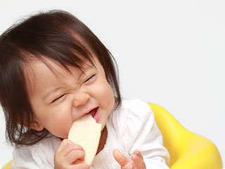 パンを食いちぎろうして力む赤ちゃん