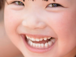 白い歯を見せて笑う女の子