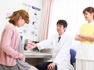 病院内で医師に診察を受ける妊婦