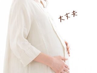 お腹を両手で押さえる妊婦