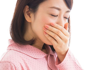 つわりで口を手で押さえる女性