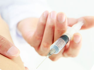 腕に注射器を近づける