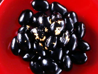 赤い小鉢の上の黒豆料理
