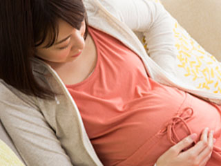 ソファにゆったりと座る妊婦