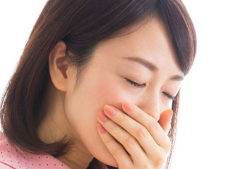 口を押さえる女性