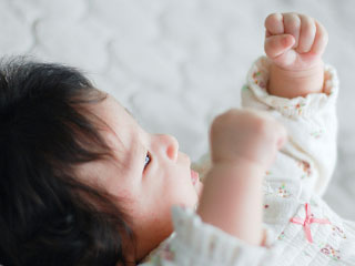 両腕を上げる赤ちゃん
