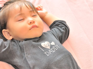 バンザイポーズで眠る赤ちゃん