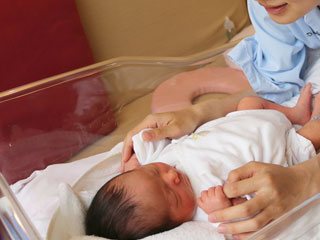 新生児を見るお母さん