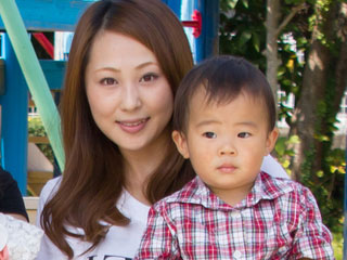 幼稚園で子供を抱き上げている母親