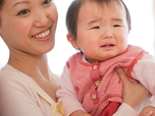 赤ちゃんを抱き上げる母親