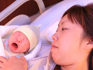 新生児を見守る母親