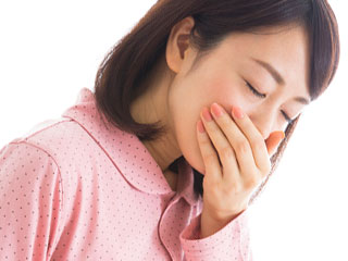 つわりで口を手で押さえる女性