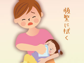 赤ちゃんの口元を拭く母親