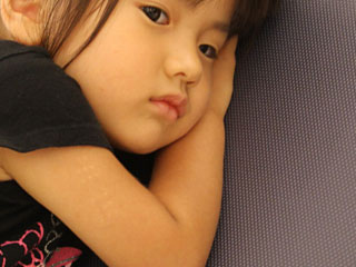 腕枕で見つめる子供