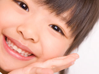 頬に手を当てて微笑む女の子