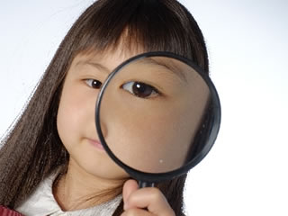 アレルギーの有無を虫眼鏡で確認する子供