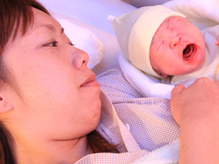出産した新生児を見守る母親