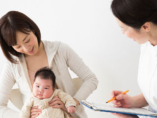赤ちゃんを抱いた母親が看護師に質問される