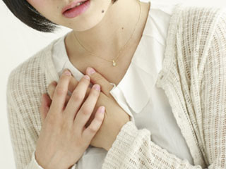 胸を押さえる女性