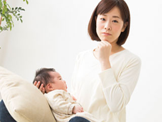 赤ちゃんを膝に載せて考える母親