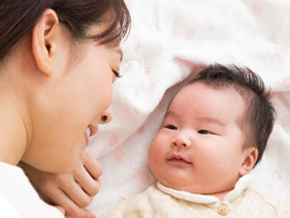 赤ちゃんと一緒に横になる母親