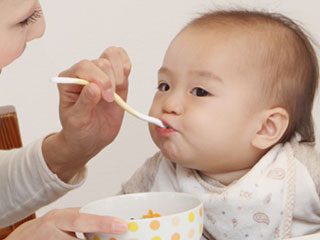 母親から離乳食を貰う赤ちゃん