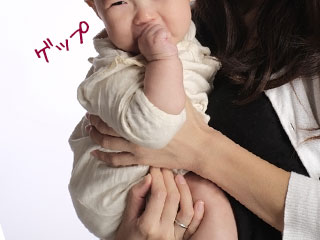 腕に赤ちゃんを座らせて抱っこする母親