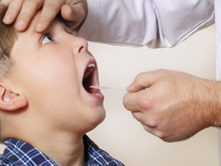 医者に口の中を診られる子供