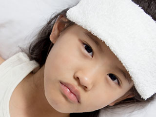 額にタオルを載せた少女
