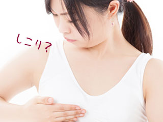 自分の胸を触る女性
