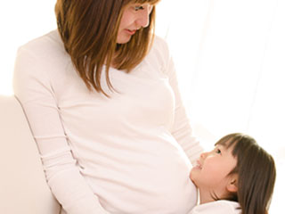 傍の子供に話しかける妊婦