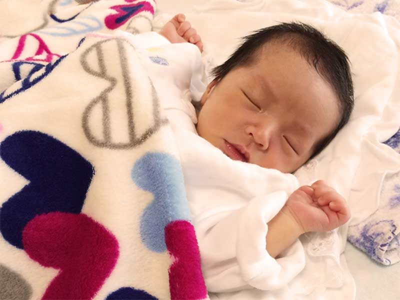 清潔な布団で寝ている新生児