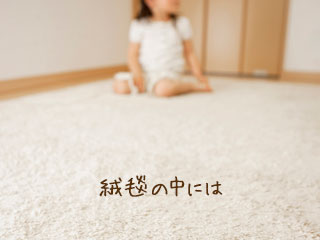 絨毯を引きつめた部屋に座る子供