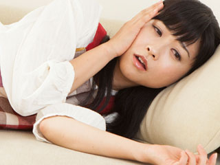 ソファに横になって休む女性