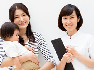 看護師と赤ちゃんを抱いた母親
