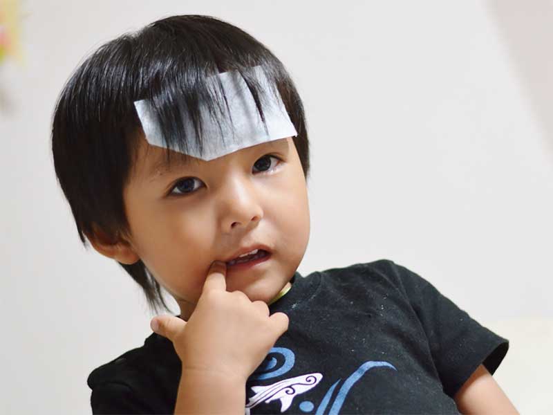 熱が出ていておでこに冷えピタを張っている男の子