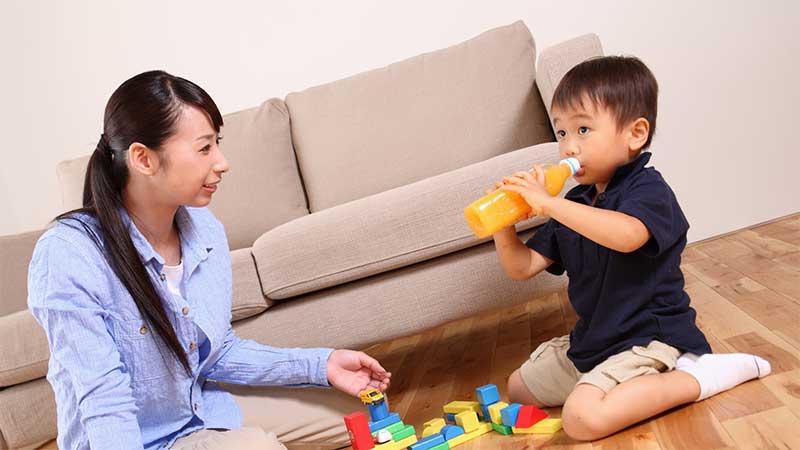 部屋の中で母親とブロックで遊んでいる男の子