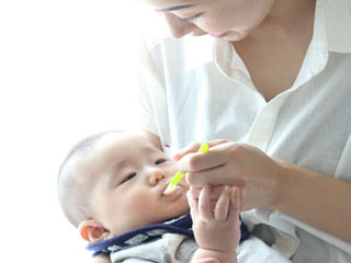 赤ちゃんに離乳食を食べさせる母親
