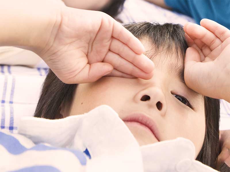 目をこすっている男の子