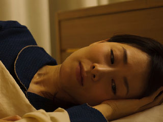 暗い表情で考えこむ女性
