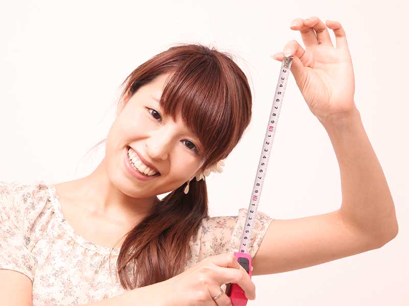 メジャーを手に持っている母親