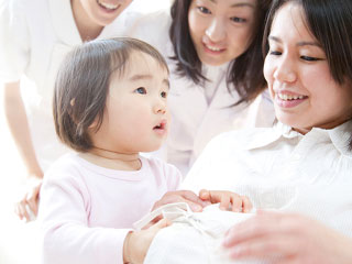 妊婦のお母さんのお腹に触る子供
