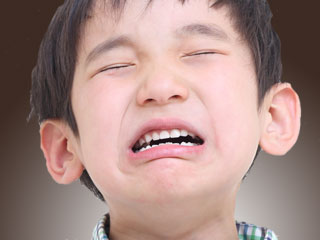 目を閉じたまま泣く子供