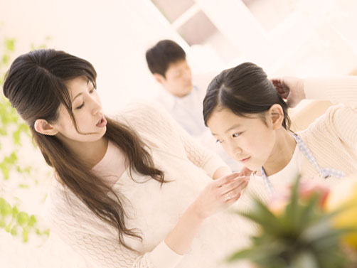 母親に首の後ろの痛みを伝えている女の子
