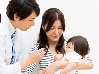 抱っこした赤ちゃんを医者に診せる母親