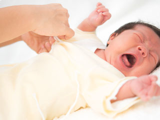 着替えをする新生児
